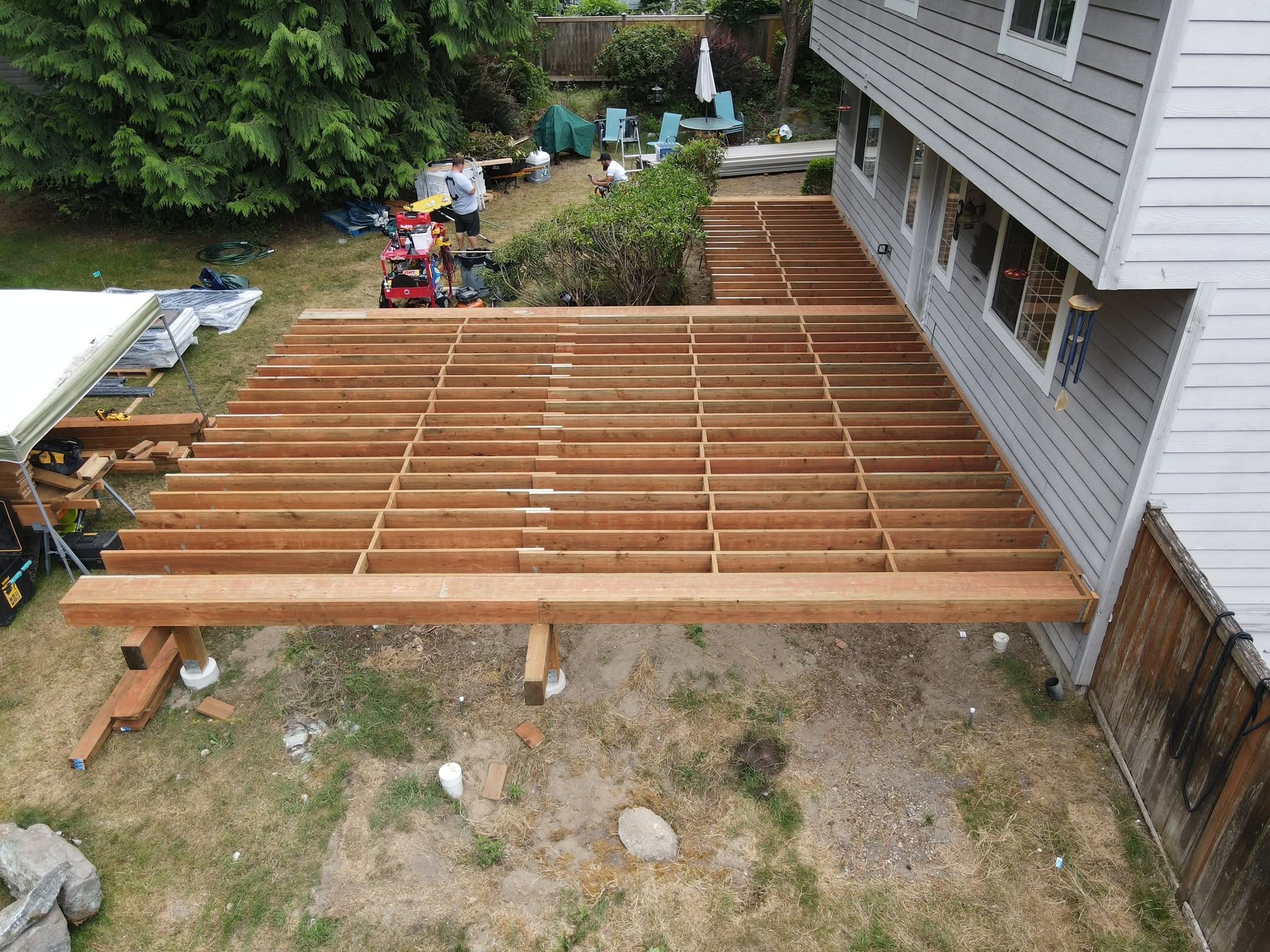 Aerial view of deck frame under construction — joists and posts before decking boards